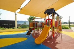 a playground with a slide in a park at Green Haven 3BR Villa-Golfside Grandeur-Emmar South in Dubai