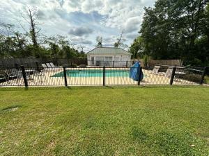a black fence in a yard with a swimming pool at Baymont by Wyndham Thomasville in Thomasville