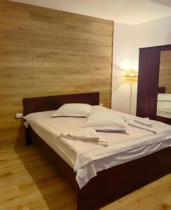 a bed with white sheets and pillows in a bedroom at Voinescu House - Natural Living & Eating in Şimon +115 photos
