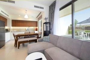 salon z kanapą i stołem w obiekcie Green Haven 3BR Villa-Golfside Grandeur-Emmar South w Dubaju