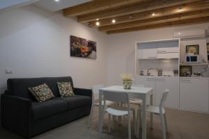 sala de estar con mesa, sofá y cocina en Baaria Apartments, en Bagheria