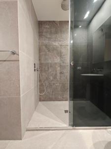 a shower with a glass door next to a sink at Baaria Apartments in Bagheria