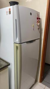 een witte koelkast met magneten in de keuken bij Quarto Privativo Zona Sul RP in Ribeirão Preto