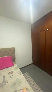 een kleine slaapkamer met een bed en een kast bij Quarto Privativo Zona Sul RP in Ribeirão Preto