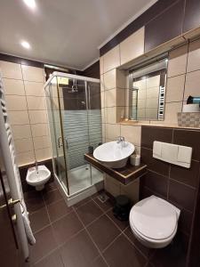 La salle de bains est pourvue de 2 lavabos, d'une douche et de toilettes. dans l'établissement IANIS Apartment, à Orăştie