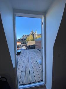 uma porta aberta com vista para um deque em Apartment City Center Terrace with Iconic View em Gouda