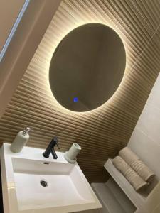 a bathroom with a sink and a round mirror at Apartment City Center Terrace with Iconic View in Gouda