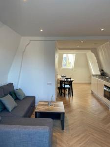 een woonkamer met een bank en een tafel bij Apartment City Center Terrace with Iconic View in Gouda