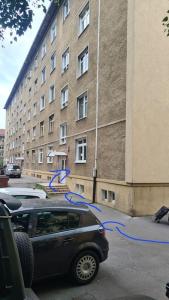 une voiture garée devant un bâtiment avec des fils bleus dans l'établissement Apartmán BB-Centrum1, à Banská Bystrica
