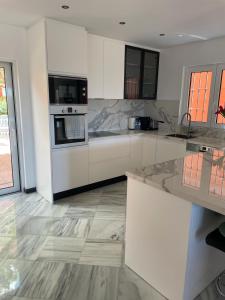 a large kitchen with white cabinets and appliances at Luxury villa in the heart of the city of Marbella Spain. in Marbella