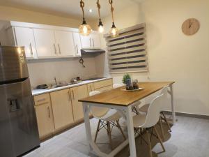 a kitchen with a wooden table and white cabinets at Tortugas in San Carlos