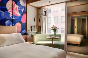 una camera con letto, sedia e tavolo di The BoTree - Preferred Hotels and Resorts a Londra