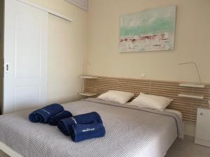 Un dormitorio con una cama con toallas azules. en Seafront lovely house - Kat's rentals, en Loutsa