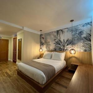 een slaapkamer met een groot bed en een schilderij aan de muur bij JaguatiricaCoffee Hospitality in Monte Verde