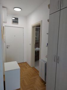 an empty room with a white door and a bathroom at Evelin Apartment in Belgrade