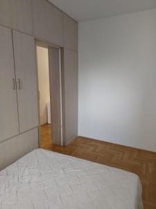 an empty room with a bed and a closet at Evelin Apartment in Belgrade