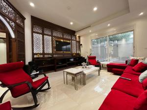 a living room with red furniture and a flat screen tv at شقة مريحة فاخرة Cozy apartment, luxury with fun in Jeddah