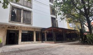 a building with glass doors on a street at Hotel Laureles 70 in Medellín
