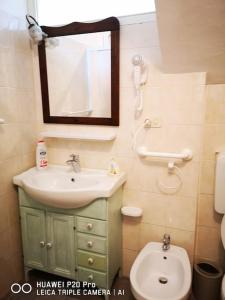 a bathroom with a sink and a toilet and a mirror at Casa Ethan intero alloggio in Ceres