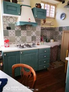a green kitchen with a sink and a stove at Casa Ethan intero alloggio in Ceres