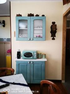 een keuken met een blauwe kast en een magnetron bij Casa Ethan intero alloggio in Ceres