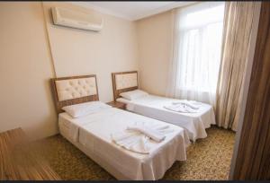 a hotel room with two beds and a window at KOSA OTEL in Marmaris