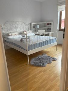 a bedroom with a bed and a wooden floor at Ełk Blue Apartment przy promenadzie in Ełk