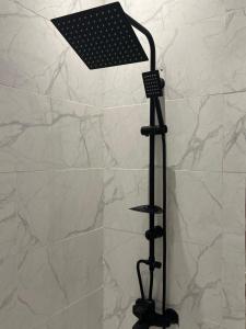 a black shower light in a bathroom with marble walls at شقه بغرفة نوم واحدة ودخول ذكي in Riyadh