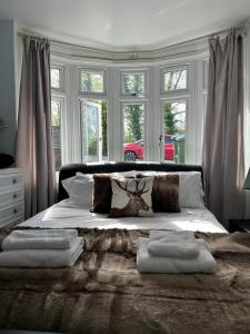 南安普敦的住宿－Accessible 3-bedroom bungalow with patio +driveway，卧室配有带枕头的床和鹿