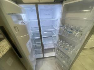um frigorífico aberto cheio de garrafas de água em The karaoke palace! em Fort Worth