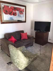 sala de estar con sofá y TV de pantalla plana en Casa Iriri, en Anchieta