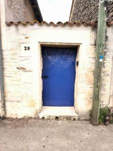 a blue door in the side of a building at La porte Bleue in Neuville-de-Poitou