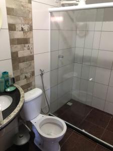 a bathroom with a toilet and a shower and a sink at Casa Iriri in Anchieta