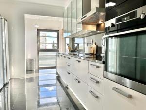 里斯本Modern & Spacious APT with River View的配有白色橱柜和黑色家电的厨房