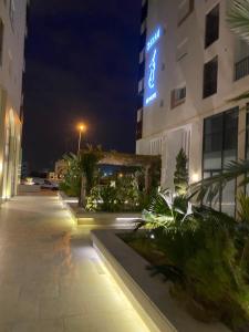 un bâtiment avec un panneau la nuit dans l'établissement Coquette appartement sahloul 4, à Sousse
