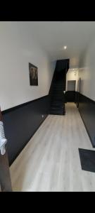 um quarto vazio com uma escada e um quadro na parede em L'Elégance 005 em Cambrai