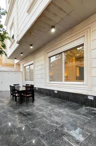 um pátio com uma mesa e cadeiras ao lado de uma janela em شقة مريحة فاخرة Cozy apartment, luxury with fun em Jidá