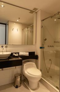 a bathroom with a toilet and a sink and a shower at One Sixteen Hotel in Bogotá