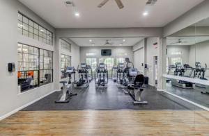 a gym with treadmills and machines in a room at Urban Haven near NRG Stadium in Houston