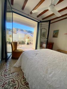 a bedroom with a bed and a sliding glass door at Costa Blanca belle maison entre mer et montagne in Adsubia