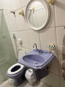 uma casa de banho com um lavatório azul e um WC. em Hotel Calcinfer em São João del Rei