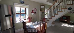 a dining room with a table and a staircase at Mortara Cottage V31KV24 in Ballylongford +26 photos