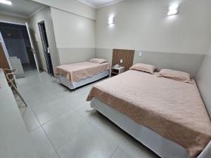 um quarto com duas camas num quarto em Spazzio diRoma em Caldas Novas