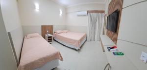 a hospital room with two beds and a mirror at Spazzio diRoma in Caldas Novas +63 photos