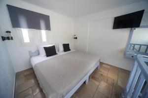 a bedroom with a white bed with two pillows on it at Anthelia Apartments in Myrties