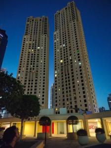 twee hoge gebouwen in een stad 's nachts bij Sansa Beach Hostel in Dubai