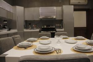 una cocina con una mesa con platos y utensilios. en شقة مريحة فاخرة Cozy apartment, luxury with fun, en Yeda