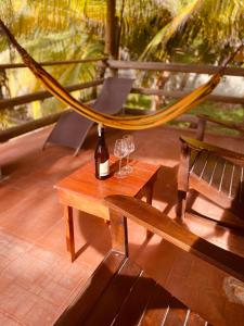 uma mesa com dois copos de vinho e uma rede de descanso em Gaia - Casa de Playa em San Bernardo del Viento