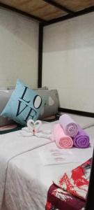 a bed with a hello kitty pillow and towels on it at Homey Inn-Olango Island Staycation ,block 1 lot 15 in Lapu Lapu City