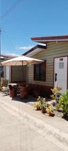 una casa con un paraguas delante en Homey Inn-Olango Island Staycation ,block 1 lot 15, en Lapu Lapu City